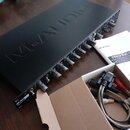 Černý rackový zvukový rozhraní s nápisem M-AUDIO na horním krytu. Na předním panelu jsou viditelné knofíky a konektory, v levém dolním rohu je logo M…