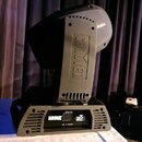 Šedý světelný efekt typu moving head s černým základem. Na boku horní části je vyražen nápis CHAUVET, na předním ovládacím panelu jsou vidět názvy RO…