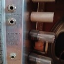 Detail zadní strany zesilovače s kovovým panelem. Na panelu jsou vstupy označené nápisy MICROPHONE a INSTRUMENTS, přepínač FOOT SWITCH a text MODEL 1…