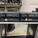 Dvě černé rackové jednotky značky LD SYSTEMS s označením ME100 UHF PLL STEREO TRANSMITTER. Každá jednotka má displej, ovládací tlačítko SET a vstup p…