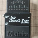 Černý ladič s nápisem Auto Chromatic Tuner SR-3000 a logem Matrix na spodním tlačítku. V horní části je displej s nápisy TUNE ON a IN TUNE, pod který…