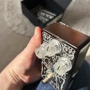 Kytarový efekt pedál s hnědým dřevěným povrchem a bílými ornamentálními vzory. Na přední straně jsou tři průhledné plastové knofíky a jeden kovový př…