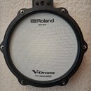 Elektronický buben s bílým mesh povrchem a černým rámem. Na horní části je nápis Roland MESH HEAD a v dolní části V-Drums s doplňkem Patent: roland.c…