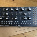 Dřevěný semi-modulární analogový syntetizátor s nápisem MOTHER-32 SEMI-MODULAR ANALOG SYNTHESIZER a logem moog. Přední panel obsahuje množství černýc…