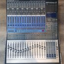 Digitální mixážní pult PreSonus STUDIOLIVE 16.4.2 v hliníkovém transportním kufru. Zařízení má šedé tělo s modrými ovládacími prvky a nápisem Digital…