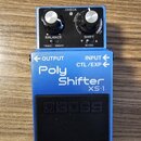 Modrý efekt pedál značky BOSS s nápisem Poly Shifter XS-1. Na horní části jsou dva ovládací knoflíky, přepínače TOGGLE a MOMENT a nápisy BALANCE, SHI…