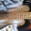 Elektrická kytara s hnědým gradientním povrchem těla a hnedým javorovým hmatníkem. Tělo má tmavý pickguard s mramorovaným vzorem. Na bílém ovládacím…