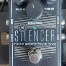 Černý kytarový pedál s nápisy THE SILENCER a noise gate/effects loop. Na spodní části je bílý nápis electro-harmonix. Pedál má tři černé ovládací kno…