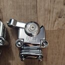 Chromovaný kovový mechanismus pedálu s nápisem Pearl. V horní části je vidět otočný knoflík s nečitelnými nápisy. Povrch je v dobrém stavu, bez vidit…