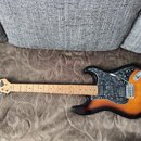 Elektrická kytara s tělem v provedení sunburst a hnědým pickguardem s texturou mramoru. Na hlavě je viditelné logo Washburn. Hmatník je vyroben ze sv…