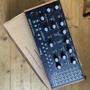 Analogový syntetizátor Moog MOTHER-32 v černém provedení s dřevěným bočním rámem. Na předním panelu jsou umístěny početné otočné knofíky, přepínače a…