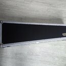 Prodloužený černý kufřík s hliníkovým rámem a kovovými rohy. Na pravé straně je nalepený zlatý štítek s nápisem ROCKCASE. Povrch kufříku i rám vypada…