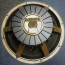 Fotografie znázorňuje zadní stranu reproduktoru s kovovým rámem a magnetem. Na středovém krytu je nápis MCKENZIE Loudspeakers for the Professional a…