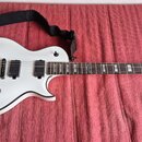 Bílá elektrická kytara s černým lemováním korpusu a hmatníkem. Na hlavě je viditelné logo Washburn a nápis PRO SERIES. Nástroj má dva humbuckery, tři…