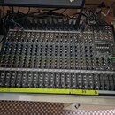 Šedý mixážní pult s mnoha ovládacími prvky, posuvníky a zapojenými kabely. Na pravé straně je vidět nápis ProFX12v2 a READY FX effects engine. V doln…