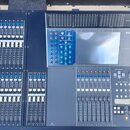Velký digitální mixážní pult s tmavě šedým povrchem a modrými prvky. Na pravé straně horního panelu je logo YAMAHA a označení modelu M7CL. Zařízení o…