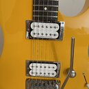 Žlutá elektrická kytara s hnědým hmatníkem. Nástroj má dva bílé humbuckery s nápisem Seymour Duncan a chromovaný tremolo systém. Na spodní části most…