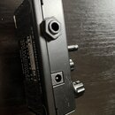 Černý kytarový efekt v kovovém šasi. Na boku je vidět nápis www.amtelelectronics.com a logo MT electronics M-D, dále texty: "brand by S. Chirnov Spb"…