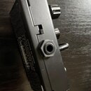 Černý obdélníkový efekt pedál z kovového materiálu. Na boku je viditelný nápis „www.amtelectronics.com“ a označení modelu „M-1“. Zařízení má na pravé…