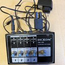 Černý 4kanálový mixér s bílým nápisem DEXON®, DMC 1400 a popisem 4 channel mini mixer. Zařízení má čtyři regulační knoflíky označené LEVEL 1 až LEVEL…