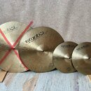 Čtyři mosazné činely různých velikostí s viditelným kovaným povrchem. Na každém je nápis „istanbul Agop Handmade cymbals from Turkey“. Činely jsou op…