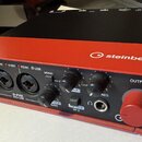 Červeně a černě provedené audio rozhraní s nápisem steinberg a označením modelu UR22C AUDIO INTERFACE 32-bit/192kHz. Přední panel obsahuje dva kombin…