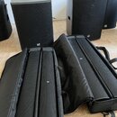 Dva černé aktivní reproduktory s mřížkou a logem LD Systems. K reproduktorům jsou přiloženy dva černé přepravní vaky s logem LD. Všechny předměty jso…
