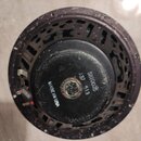 Fotografie zachycuje zadní část černého reproduktoru s kovovým rámem. Na magnetu jsou bílé nápisy „5810025“, „137 513“ a „MADE IN USA“. Povrch rámu i…