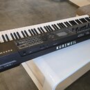 Černý digitální klavír s bílými a černými klávesami. Na přední hraně je vlevo nápis KURZWEIL pc4 a vpravo nápisy KURZWEIL a PC4. Ovládací panel obsah…