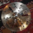 Kovový činel s vryty a otvory v povrchu. Na povrchu je nápis CUSTOM a logo Zildjian. Činely vykazují známky používání v podobě drobných škrábanců a z…