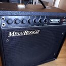 Černý kytarový kombozesilovač s černým textilním krytem reproduktoru. Na předním panelu je nápis Mesa/Boogie a v pravém horním rohu logo MESA ENGINEE…