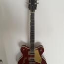 Hollow-body elektrická kytara v tmavě hnědé barvě s f-otvory. Na hlavě je bílý nápis GRETSCH a na pickguardu vertikální nápis GRETSCH. Nástroj má dva…