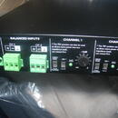 Detailní pohled na ovládací panel černého elektronického zařízení. Jsou zde vidět zelené svorkovnice v sekci BALANCED INPUTS pro CH 1 a CH 2, přepína…