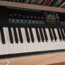 Černý MIDI kontrolér s klávesnicí. Na levé straně je bílý nápis nektar a vpravo nápis PANORAMA T6. Horní panel obsahuje několik posuvníků, ovládací k…