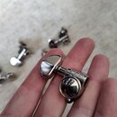 Fotografie zachycuje kovový ladicí mechanismus v chromovaném provedení, který drží ruka. Na horní části mechanismu je vyryt nápis GROVER. V pozadí js…