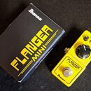 Žlutý efekt pedál s nápisy FLANGER MINI a Ibanez. Pedál má tři ovládací knoflíky s popisky DEPTH, REGEN a SPEED, vstup INPUT a výstup OUTPUT. Vedle p…