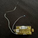 Fotografie znázorňuje elektrický snímač v kovovém zlatavém krytu s připojenými vodiči. Na spodní straně je vyražen nápis PRS USA a nalepená bílá štít…