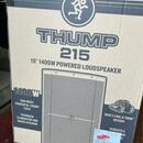 Fotografie znázorňuje papírový obal od reproduktoru. Na krabici je velký nápis THUMP 215 a text 15" 1400W POWERED LOUDSPEAKER. Dále jsou vidět nápisy…