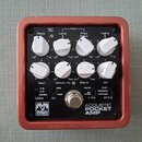 Kompaktní efekt pedál v červeném kovovém rámu s černým předním panelem. Na panelu jsou osmi bílých otočných ovladačů s popisky Bass, Level, Freq 600H…