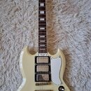 Krémově bílá elektrická kytara typu SG značky Epiphone. Na hlavě je nápis Epiphone a na krytce snímačů text Les Paul Special. Nástroj má dva humbucke…
