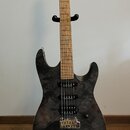 Elektrická kytara s černým korpusem s mramorovým vzorem a světle hnědým hnedobělým hmatníkem. Nástroj má tři snímače typu single-coil, jeden ovládací…