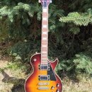 Elektrická kytara s trupem v červeno-žlutém sunburst provedení a černým pickguardem. Na hlavě hmatníku je bílý nápis jolana. Nástroj má dva humbucker…