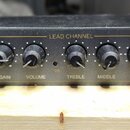 Černý kytarový předzesilovač s nápisy GUITAR PREAMP a MGP 9004. Zařízení obsahuje vstup INPUT a sekci LEAD CHANNEL s ovládacími prvky GAIN, VOLUME, T…