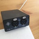 Černý kovový box s dvěma XLR konektory. Na přední straně jsou nápisy N 48 i-2, MIC 1, P 48, 2 x 6 mA a MIC 2. Nad konektory se nacházejí dvě tlačítka…
