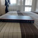 Šedý rackový audio rozhraní s červeným lemováním spodní hrany. Na levé straně je nápis Scarlett a na pravé straně logo Focusrite. Přední panel obsahu…