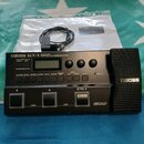Černý kytarový efektový procesor s výrazným nápisem BOSS GT-1 GUITAR EFFECTS PROCESSOR. Zařízení obsahuje displej, několik ovládacích tlačítek a výra…