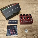 Červený efekt pedál s nápisy IMPERIUM a Cornerstone MUSIC GEAR. Na zařízení jsou vidět ovládací knoflíky s popisky GAIN, PRESSURE, TONE, VOLUME, BASS…