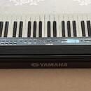 Černý digitální klavír značky YAMAHA. Na přední hraně je umístěno bílé logo a nápis YAMAHA. Ovládací panel obsahuje řadu tlačítek s bílými nápisy, vč…