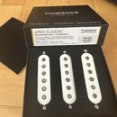 Černá krabice s nápisem TONERIDER GUITAR & BASS PICKUPS, pod kterým je uvedeno SCATTERWOUND, 5-YEAR WARRANTY a DESIGNED IN THE UK. Uvnitř jsou tři bí…