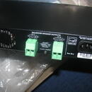 Zadní strana černého elektronického zařízení s nápisem BALANCED SPEAKER OUTPUTS. Jsou zde dva zelené svorkovnice pro kanály CH 1 a CH 2, doprovázené…